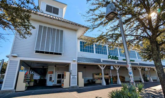 Elevated design of a grocery anchor using cement board siding, and hurricane-resistant standing seam metal roofing