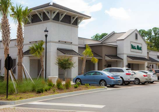 Example of an existing strip mall that has been refurbished with corbels, metal roof accents, oyster shell tabby, and coordinated trim colors along with native landscaping. These simple changes allow for greater visual compatibility with traditional/historic buildings.