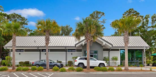 A hurricane-resistant standing seam metal roof, earth tone colors, siding and trim allow this coffee shop drive-thru to blend into the built environment.