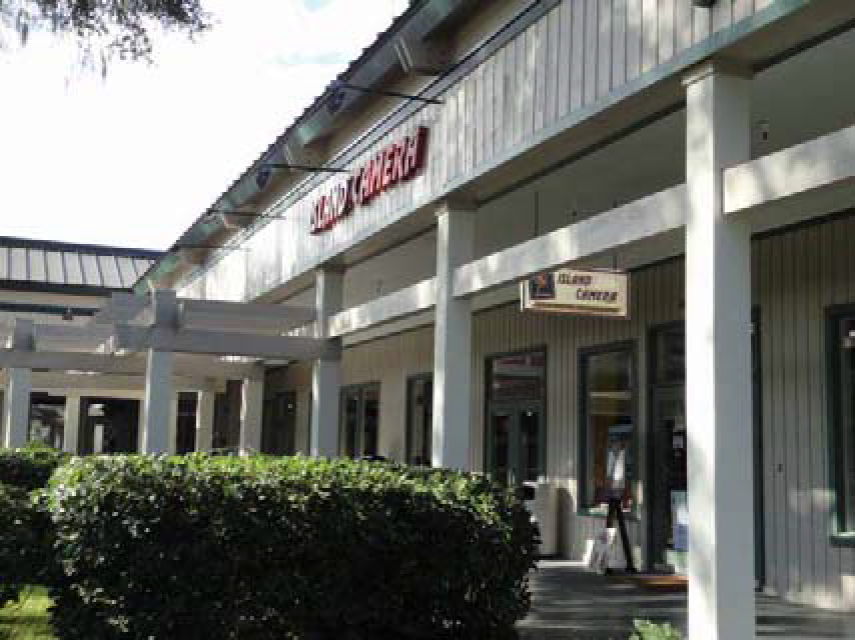 Figure 16-5-114.G.2: Example of a Tenant Space in a Shopping Center with Two Conforming Signs—One Facade Sign and One Hanging Sign Perpendicular to the Storefront