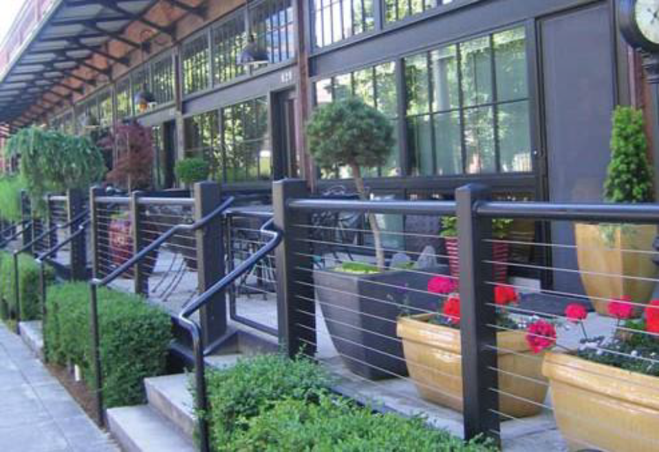 AAn example of a series of residential dooryards. Each dooryard has its own steps with railings providing separation between the dooryards of adjacent units.