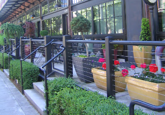 An example of a series of residential dooryards. Each dooryard has its own steps with railings providing separation between the dooryards of adjacent units.