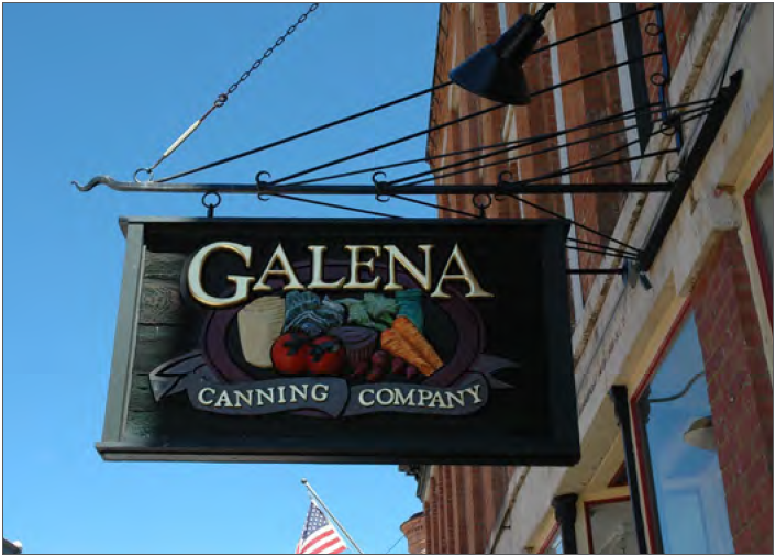 Example — Rectangular projecting sign with painted relief and decorative bracket.